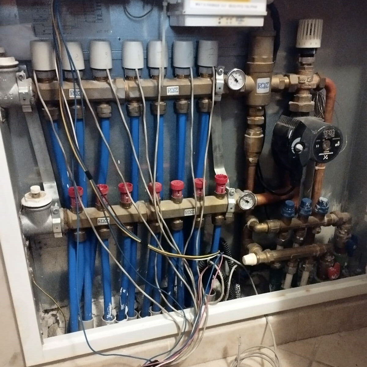 Collettore, valvole di zona, pompa, caldaia. Riscaldamento a pavimento. Collegamenti elettrici elettrovalvole di zona. Control Casa, riparazione impianto elettrico.